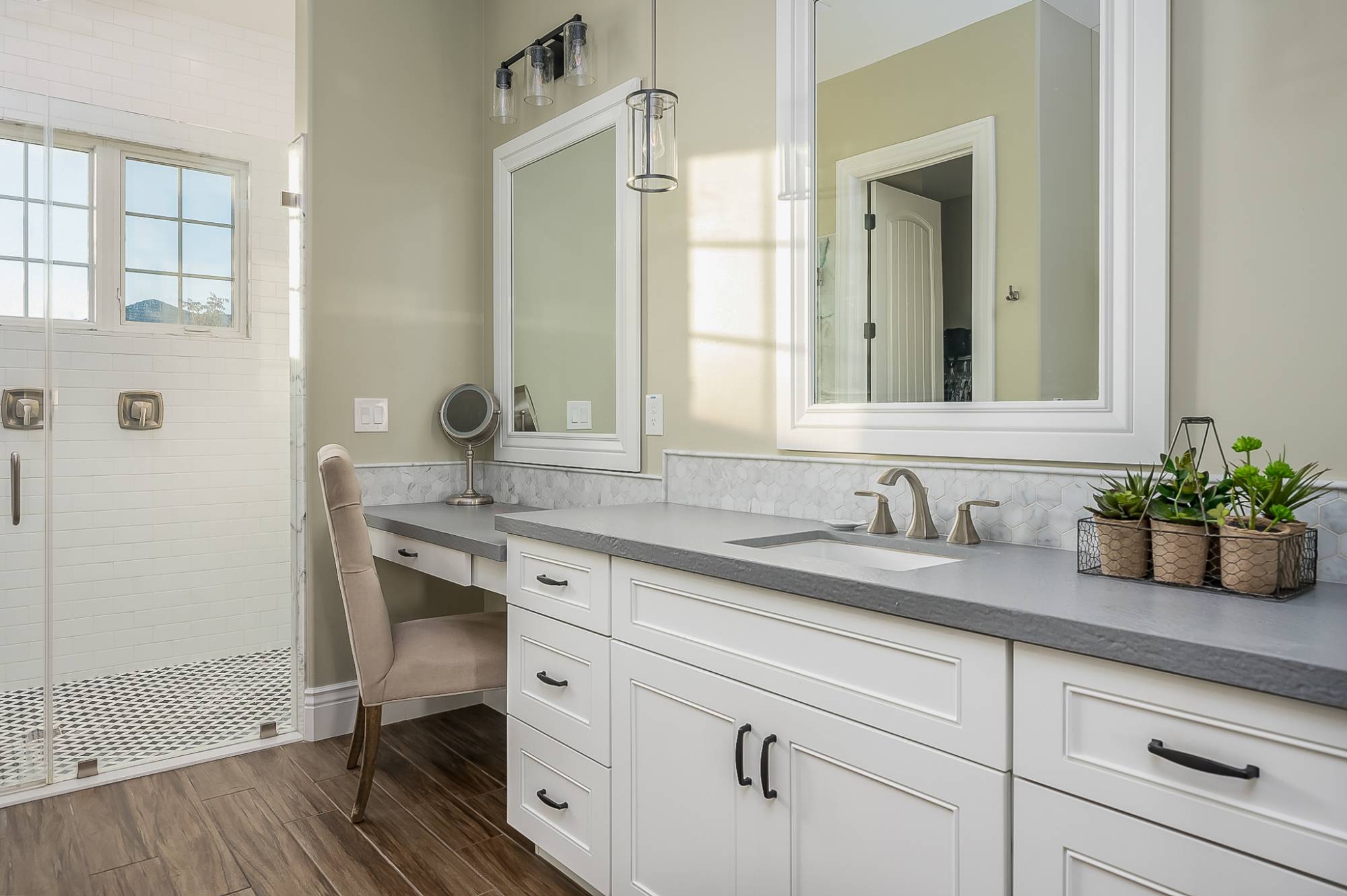 Modern, spacious white and gray bathroom with vinyl laminate flooring that looks like wood.