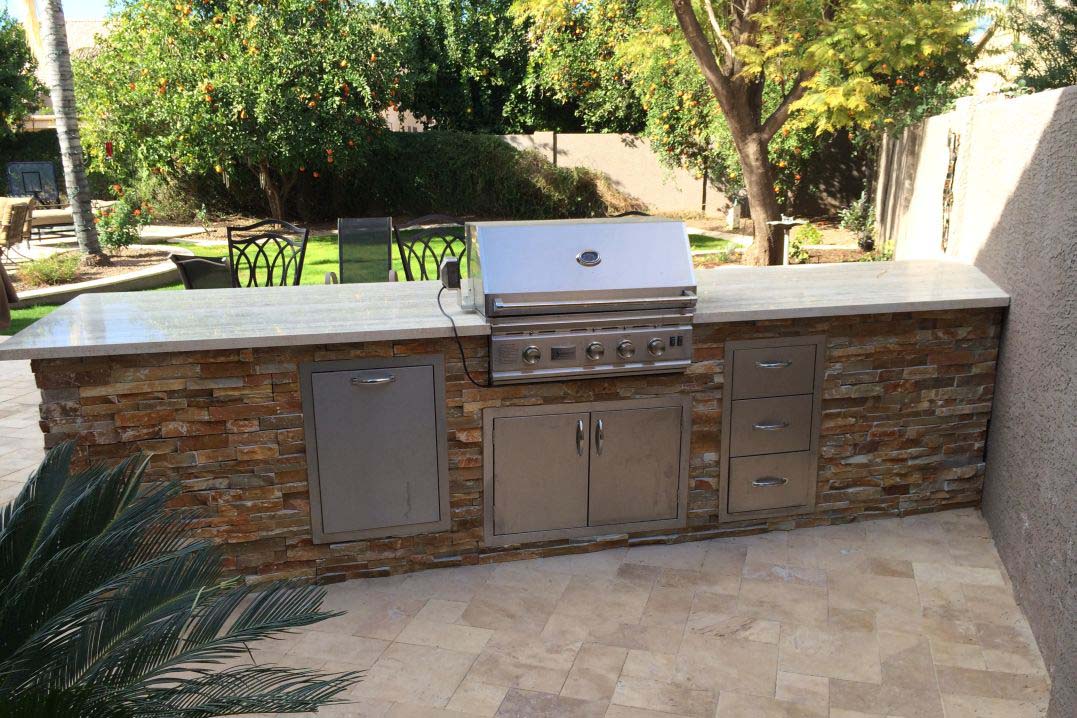 Large built-in outdoor grill on patio in backyard